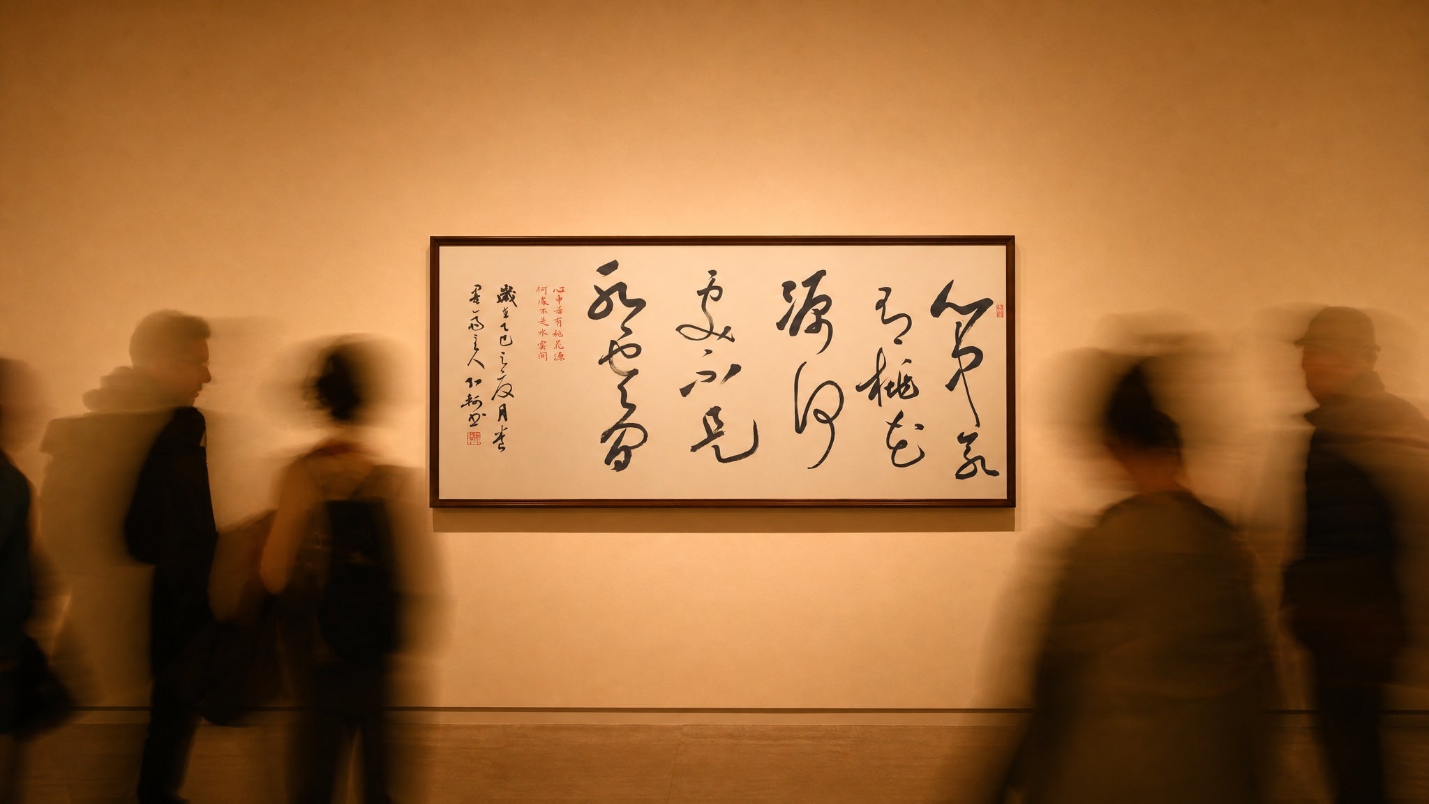 Original Chinese calligraphy displayed in a gallery as visitors move through the space