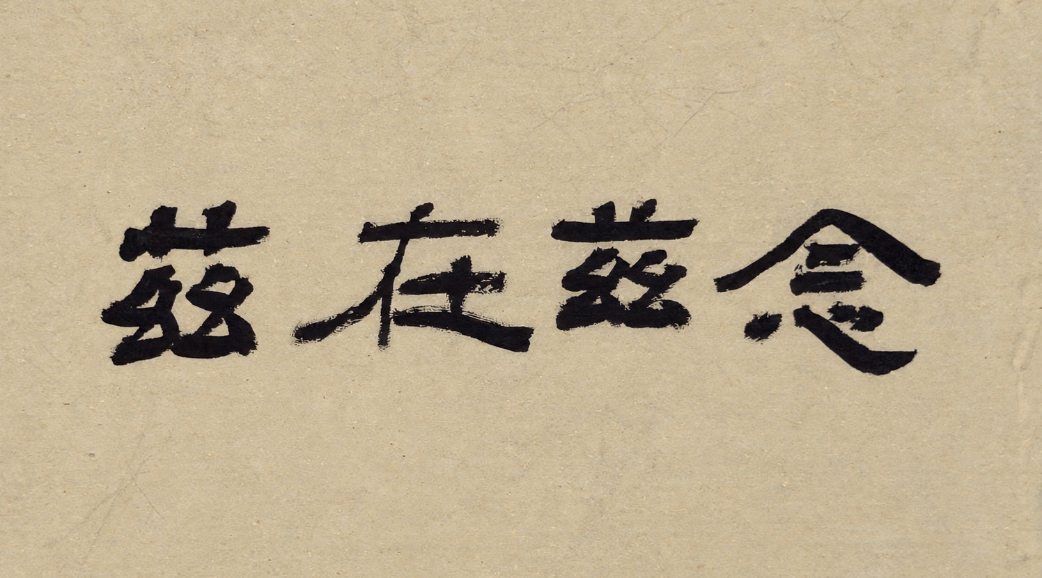 Third original: 念兹在兹 in horizontal brush calligraphy on warm paper