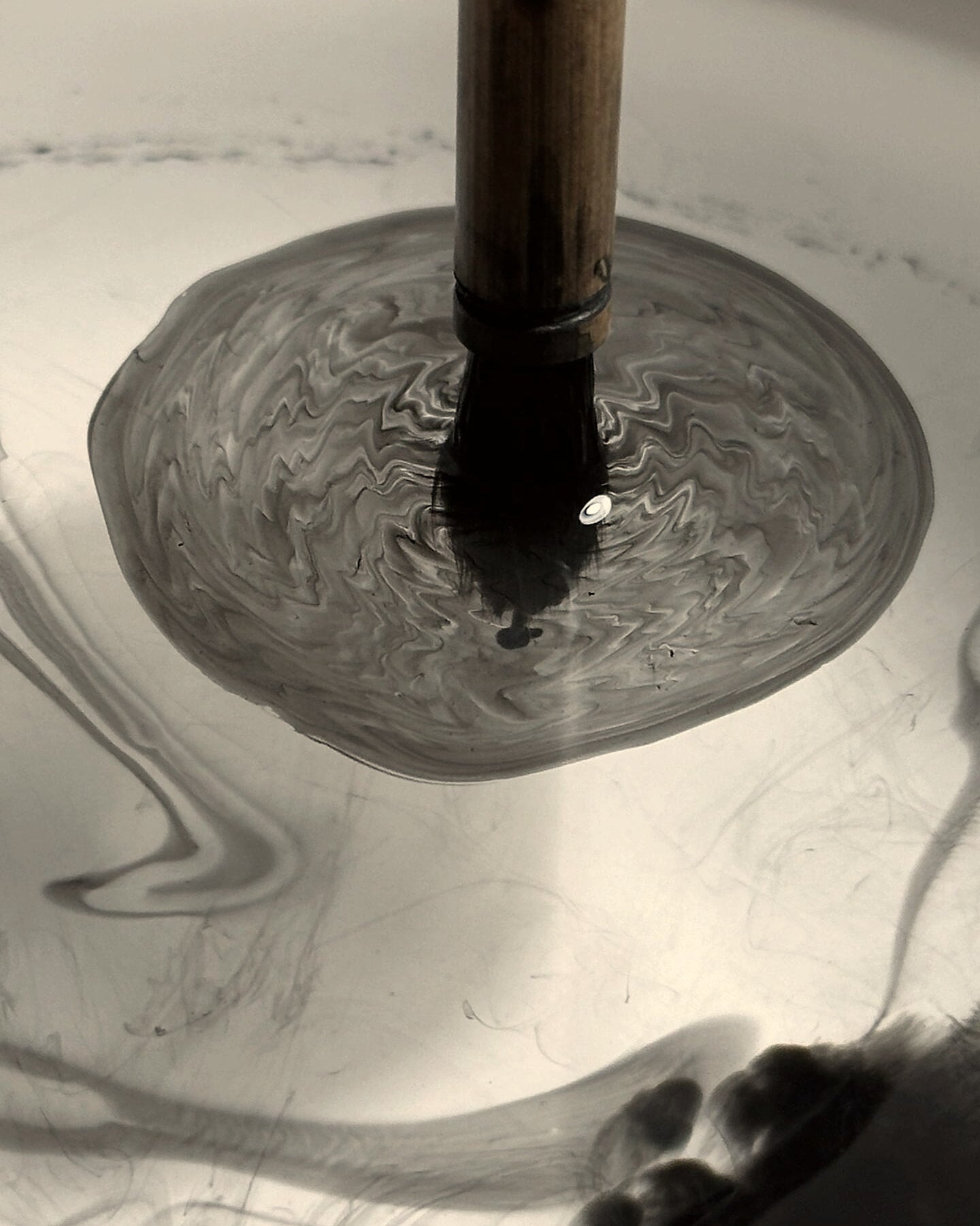 Chinese calligraphy brush meeting a pool of diluted ink